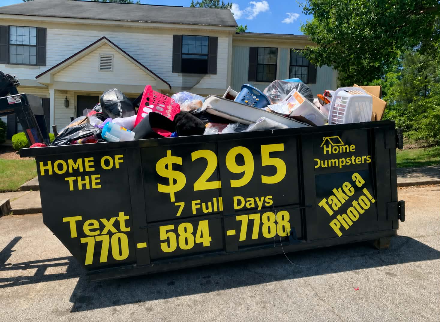 Rent A Home Dumpster’s black residential dumpster showing the $295 seven-day promotion and text number